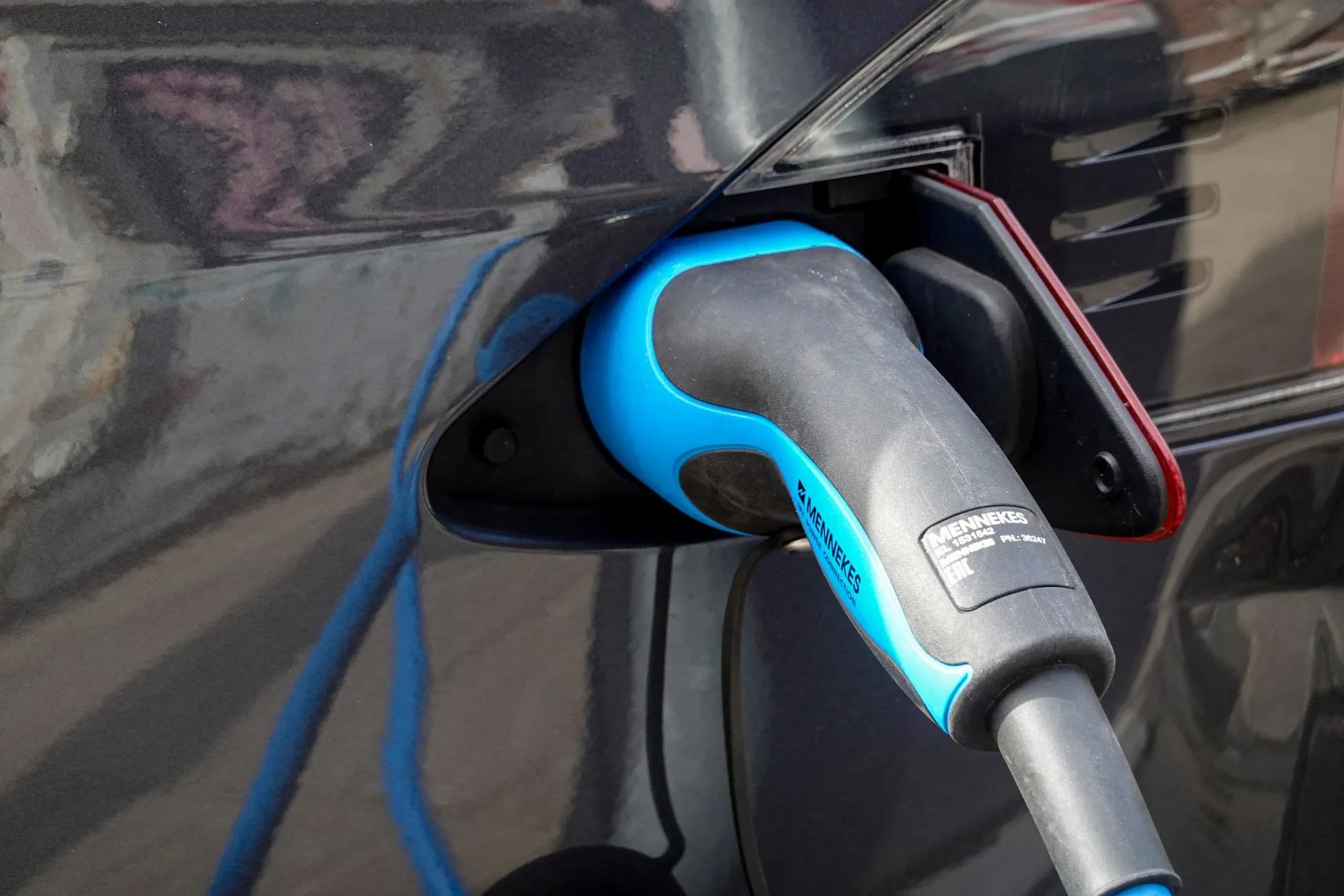 A charging cable connected to a dark electric vehicle
